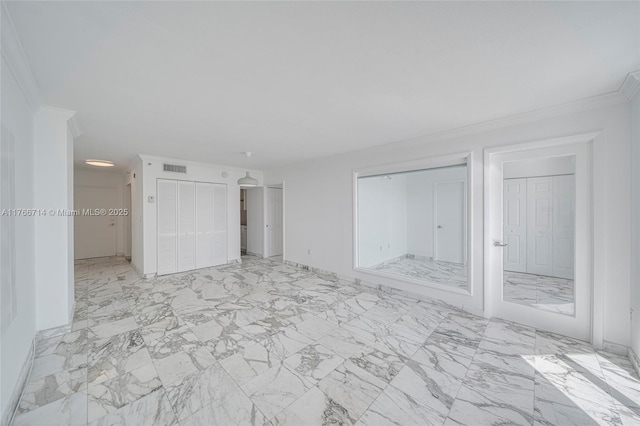 unfurnished bedroom with visible vents, marble finish floor, multiple closets, and ornamental molding