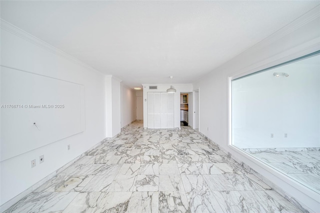 unfurnished room featuring marble finish floor and ornamental molding
