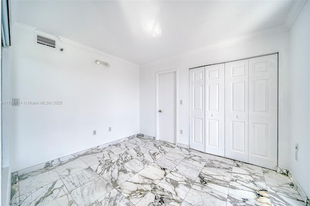 unfurnished bedroom featuring visible vents, marble finish floor, ornamental molding, and a closet