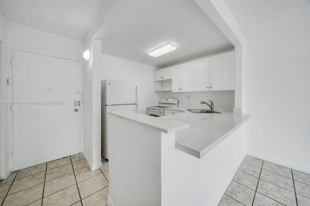 kitchen with a sink, white appliances, light tile patterned floors, and light countertops