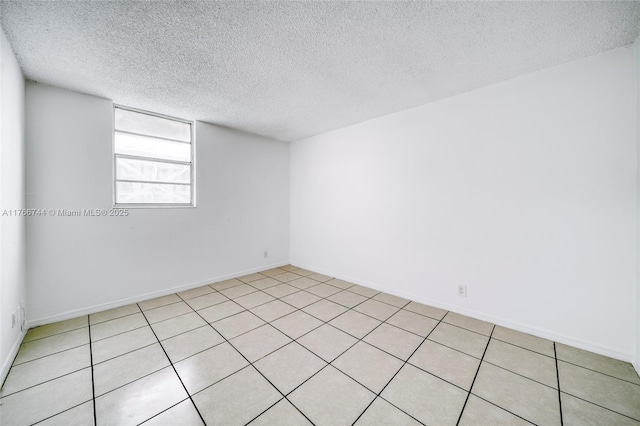 spare room with baseboards and a textured ceiling