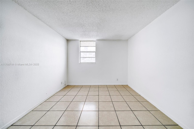 unfurnished room with light tile patterned floors and a textured ceiling