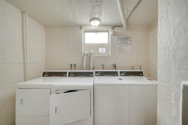 community laundry room featuring washing machine and dryer and a textured wall
