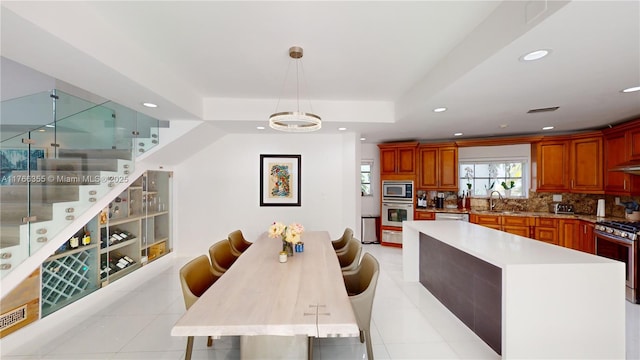 dining area featuring a tray ceiling, recessed lighting, stairway, and light tile patterned floors