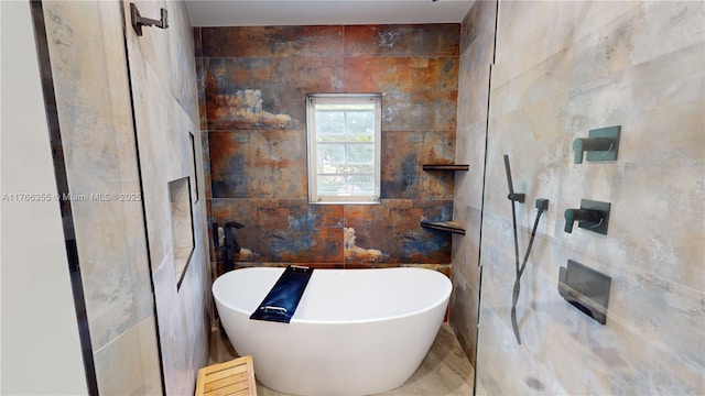 full bath featuring a freestanding tub, tile walls, and walk in shower