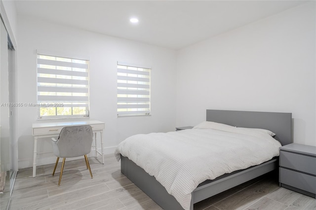 bedroom featuring baseboards, recessed lighting, and wood finish floors