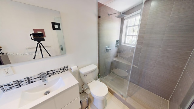 bathroom featuring toilet, vanity, decorative backsplash, and a walk in shower