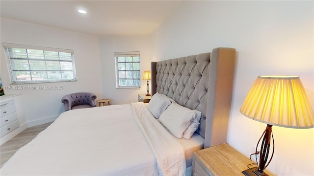 bedroom with baseboards, wood finished floors, and recessed lighting