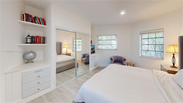 bedroom with a closet, baseboards, recessed lighting, and light wood finished floors