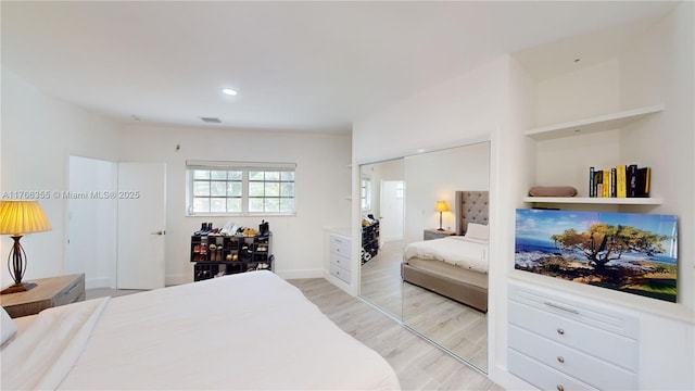 bedroom with a closet, recessed lighting, visible vents, and light wood-style floors