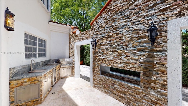view of patio with a grill, exterior kitchen, and a sink