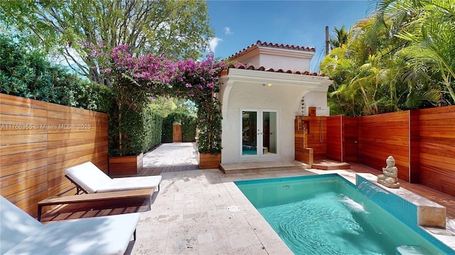 back of house with a fenced backyard, stucco siding, a patio, and french doors