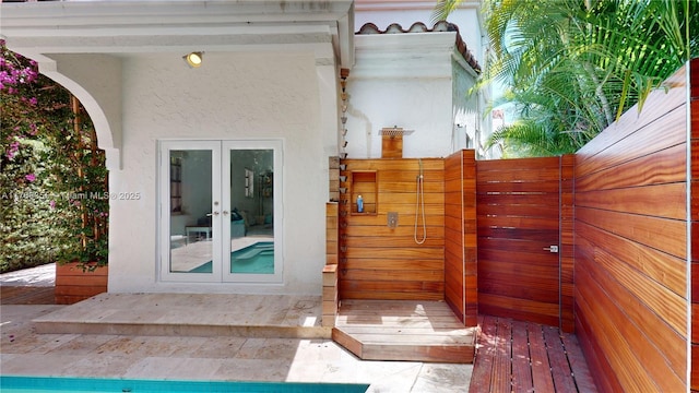 exterior space with french doors and stucco siding