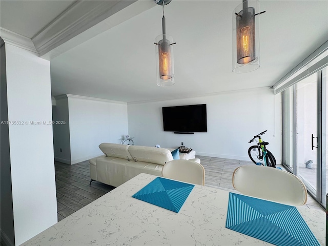 living area with baseboards, ornamental molding, and wood finished floors