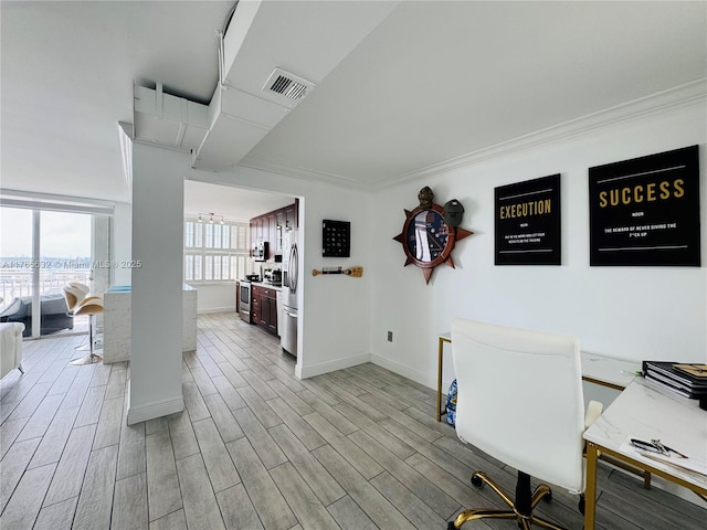 office area featuring baseboards, visible vents, ornamental molding, and wood finish floors