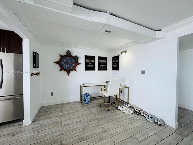 interior space featuring wood tiled floor, visible vents, crown molding, and freestanding refrigerator