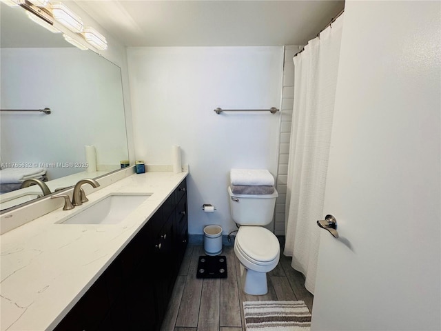 full bathroom featuring wood finished floors, toilet, and vanity