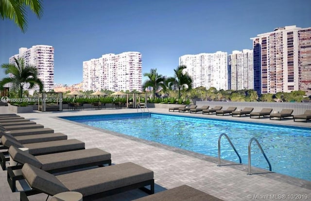 community pool with a view of city and a patio area