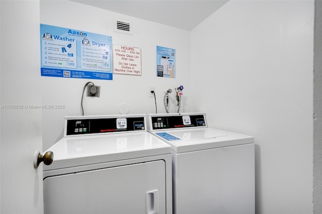 community laundry room with visible vents and washing machine and clothes dryer