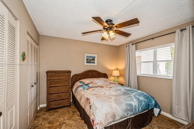1045 Country Club Dr Unit 304, Margate, FL 33063 - bedroom with baseboards, a textured ceiling, and a ceiling fan