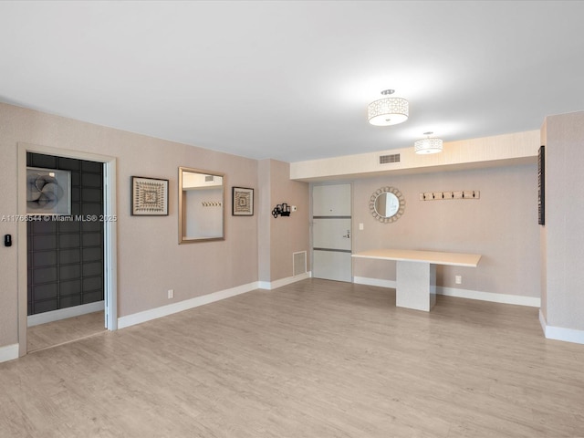 interior space with light wood-style flooring, baseboards, and visible vents