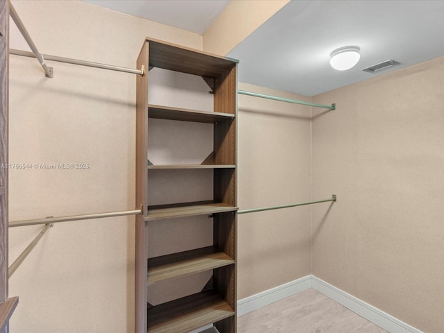 walk in closet featuring wood finished floors and visible vents