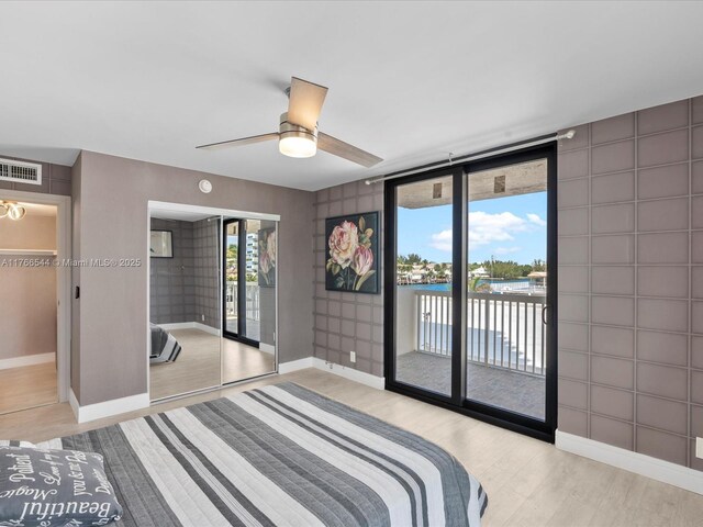 bedroom with access to exterior, visible vents, baseboards, wood finished floors, and a ceiling fan