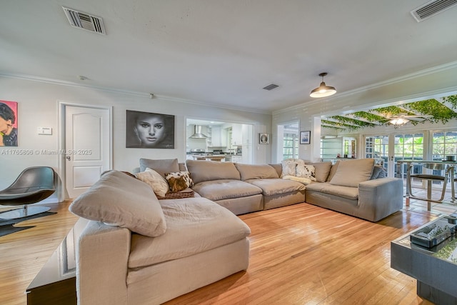 living area with visible vents and ornamental molding