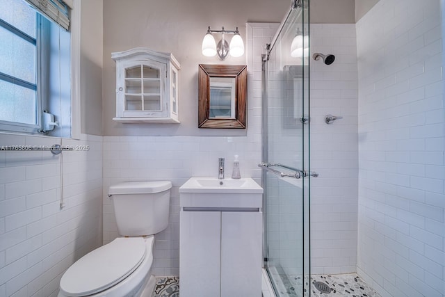 bathroom featuring a shower stall, tile walls, toilet, and vanity