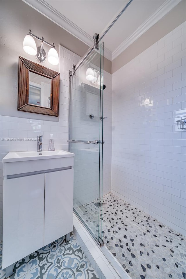 bathroom with crown molding, vanity, a shower stall, tile patterned flooring, and tile walls
