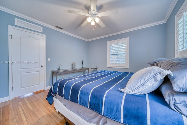 bedroom featuring visible vents, wood finished floors, ornamental molding, and a ceiling fan