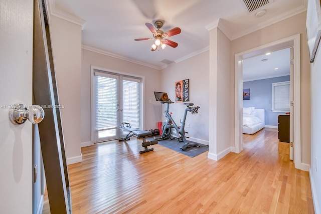 exercise room featuring baseboards, ornamental molding, ceiling fan, and light wood finished floors