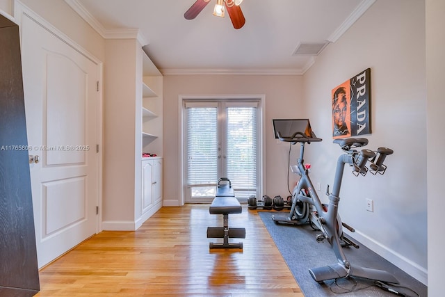 workout area featuring light wood-style flooring, visible vents, and crown molding