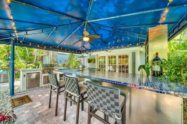 view of patio / terrace featuring an outdoor kitchen, outdoor wet bar, central air condition unit, and grilling area