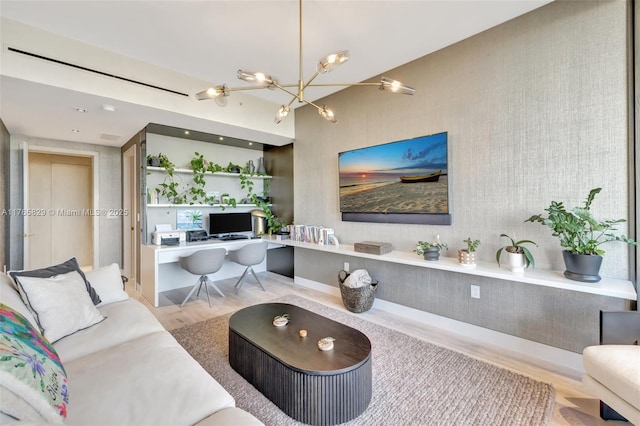 living area featuring built in desk, an inviting chandelier, and wood finished floors
