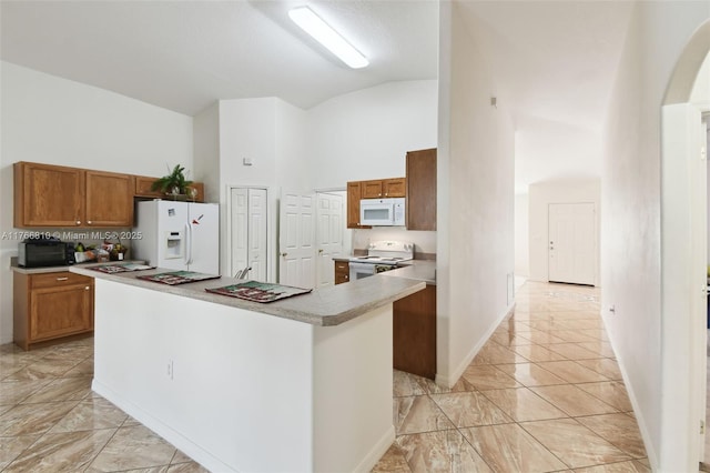 kitchen featuring a kitchen island, light countertops, arched walkways, white appliances, and high vaulted ceiling