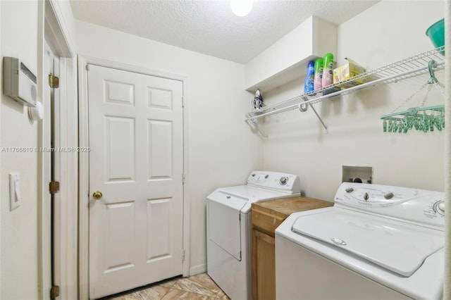 laundry area with a textured ceiling, independent washer and dryer, and laundry area