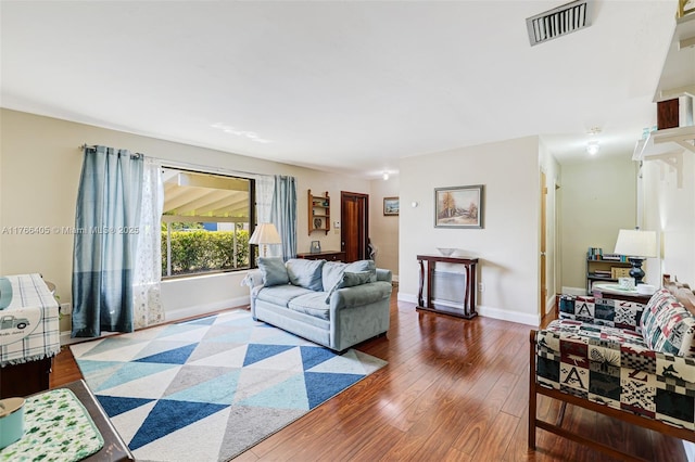 living area featuring visible vents, baseboards, and wood-type flooring