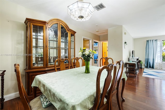 dining room with visible vents, an inviting chandelier, baseboards, and hardwood / wood-style floors