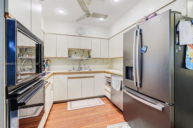 kitchen featuring ceiling fan, light countertops, appliances with stainless steel finishes, light wood-style floors, and a sink