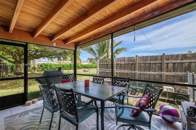 sunroom / solarium with outdoor dining space and beam ceiling