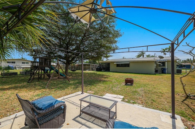 view of yard with a patio area, fence, and a playground