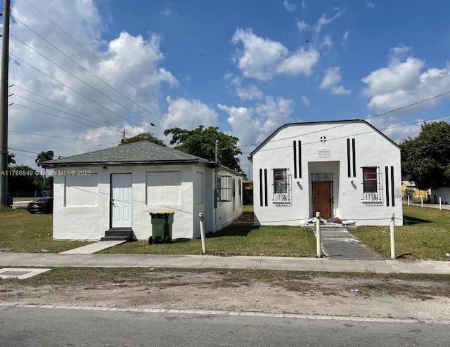view of front of home featuring stucco siding and a front lawn