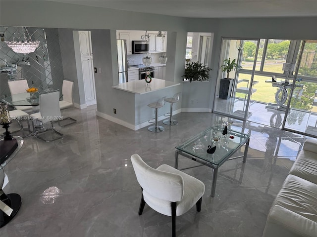 living area with baseboards and marble finish floor