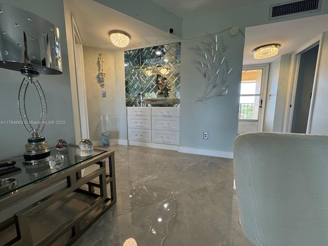 interior space with baseboards, marble finish floor, and visible vents
