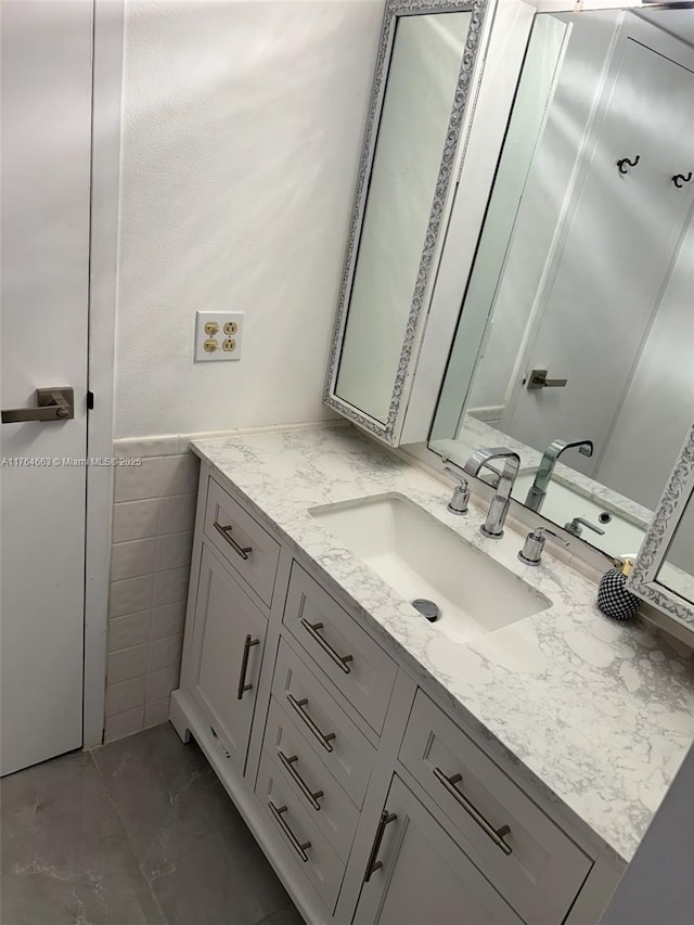 bathroom featuring marble finish floor and vanity