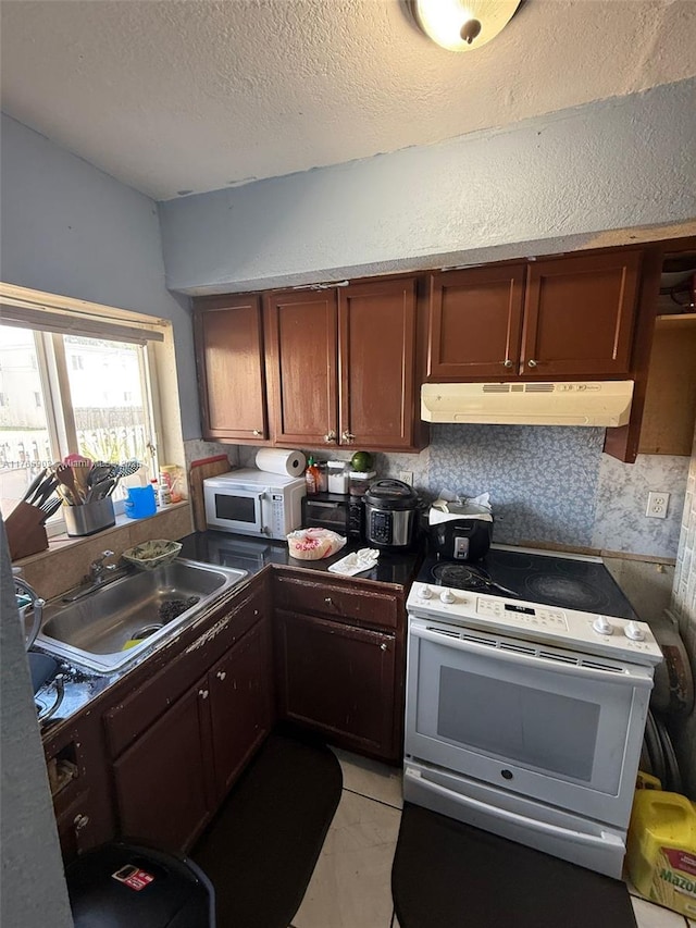 417 NW 84th St Unit 417, Miami, FL 33150 - kitchen featuring under cabinet range hood, a sink, a textured ceiling, white appliances, and light tile patterned flooring