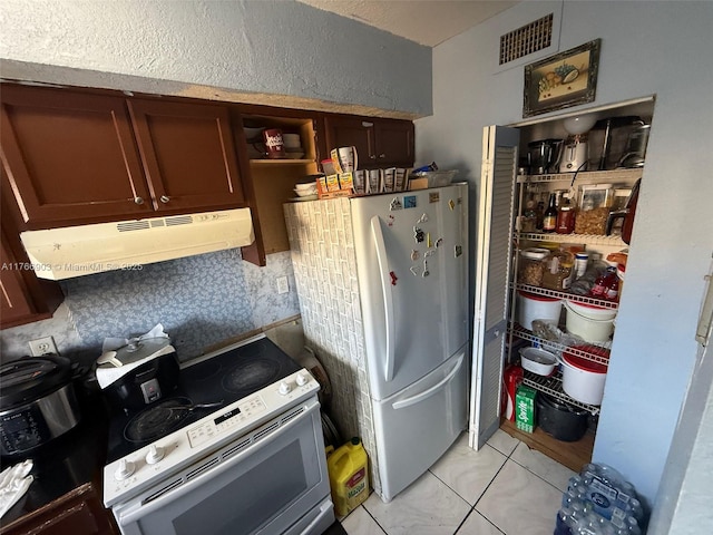 417 NW 84th St Unit 417, Miami, FL 33150 - kitchen featuring visible vents, under cabinet range hood, a textured wall, light tile patterned flooring, and white appliances