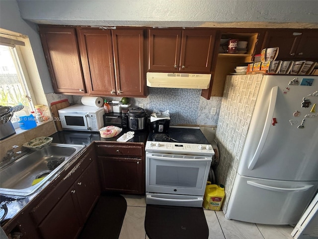 417 NW 84th St Unit 417, Miami, FL 33150 - kitchen with under cabinet range hood, a sink, dark countertops, white appliances, and light tile patterned floors