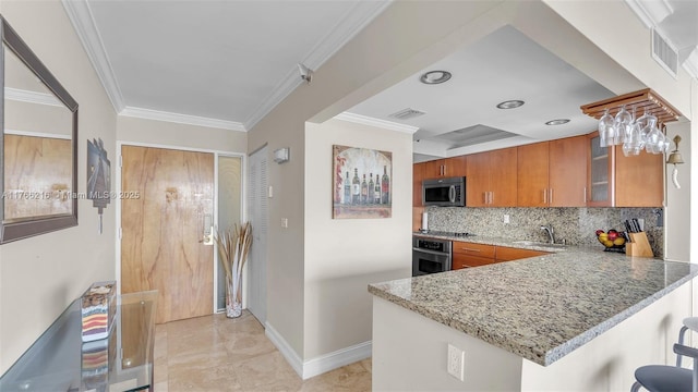 kitchen featuring visible vents, a sink, tasteful backsplash, appliances with stainless steel finishes, and brown cabinetry